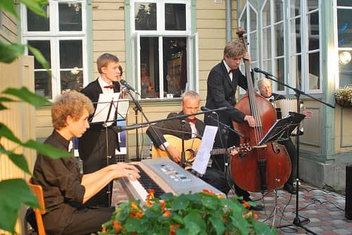 Väike ansambel klaveri ja kontrabassiga esinemas kohviku õuel
